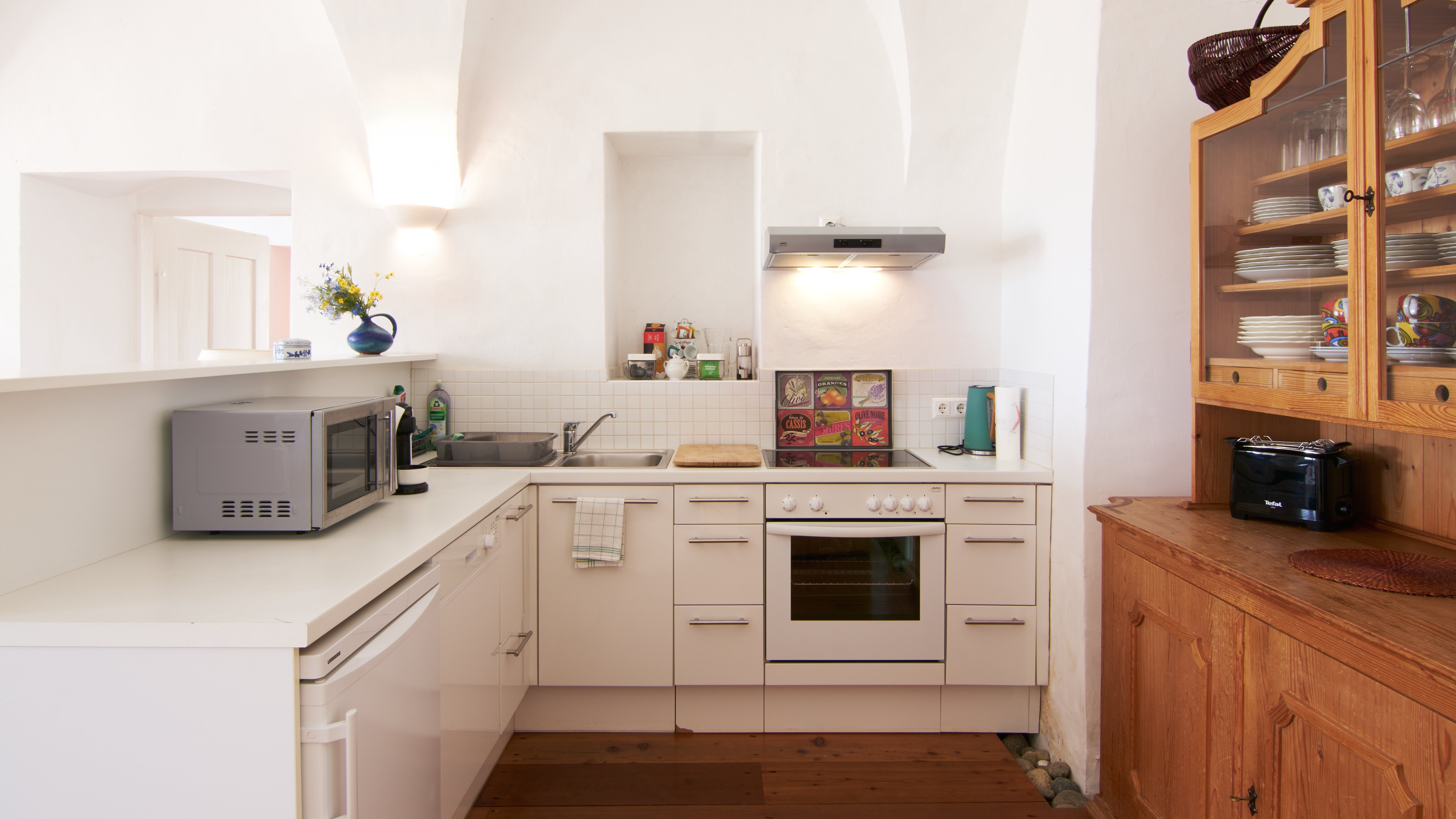 Moderne Küche mit minimalistischen Akzenten Eine helle, moderne Küche mit weißen Schränken und einem eingebauten Ofen. Die Küchengeräte sind geschickt integriert.