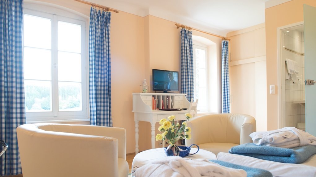 Moderne Hotelzimmer für komfortable Aufenthalte Helles Hotelzimmer mit komfortabler Sitzgelegenheit und großen Fenstern für Tageslicht