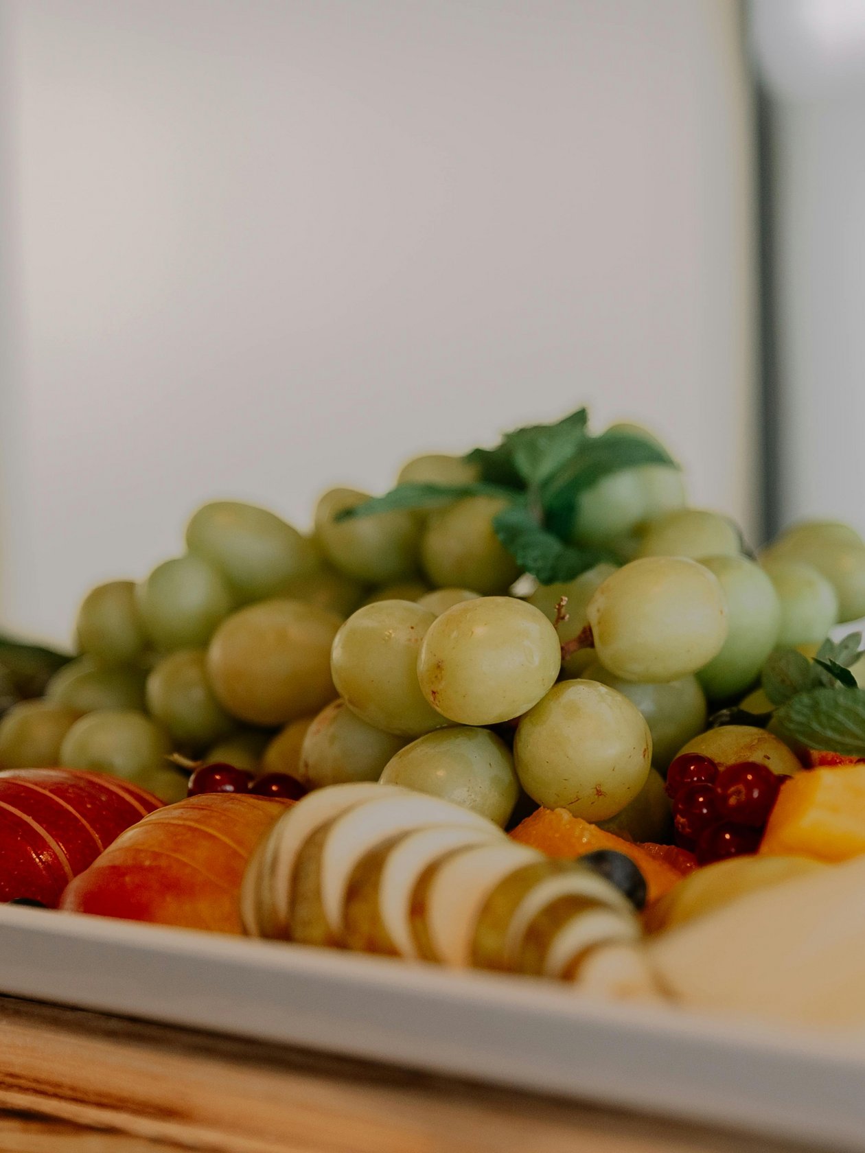 Fresh and Vibrant Fruit Platter Delight A vibrant fruit platter with assorted fresh fruits and cheese, featuring grapes and garnishes