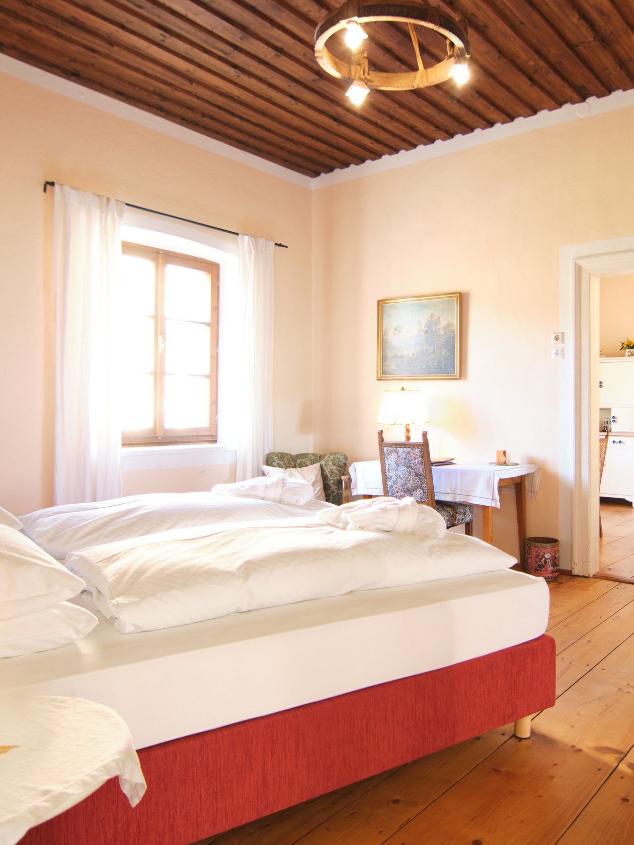 Serene Bedroom Retreat Brightly lit bedroom with a cozy bed, wooden flooring, and stylish decor elements