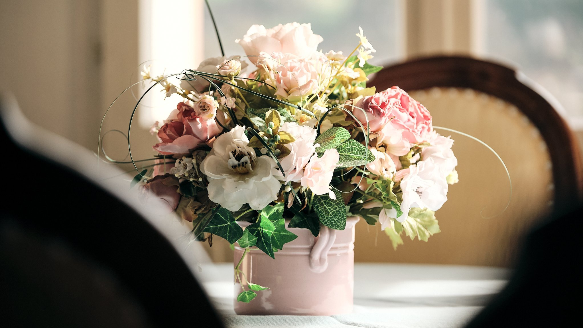 Blumige Eleganz für jedes Interieur Dekorativer Blumenstrauß in einer Vase mit verschiedenen Blumen und Grünpflanzen.