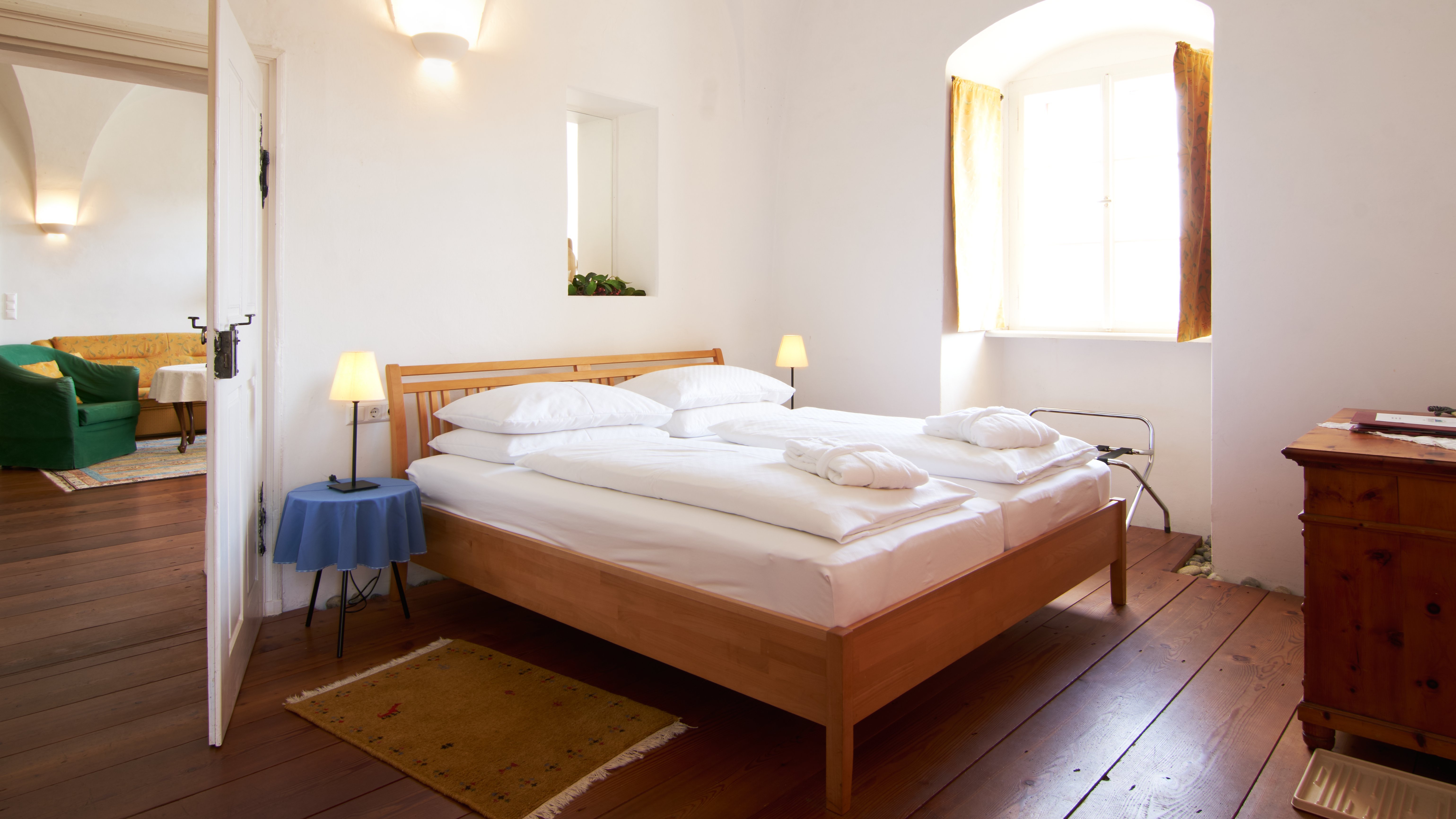 Helle Schlafzimmeratmosphäre Minimalistisch eingerichtetes Schlafzimmer mit Holzbetten und großen Fenstern für Tageslicht