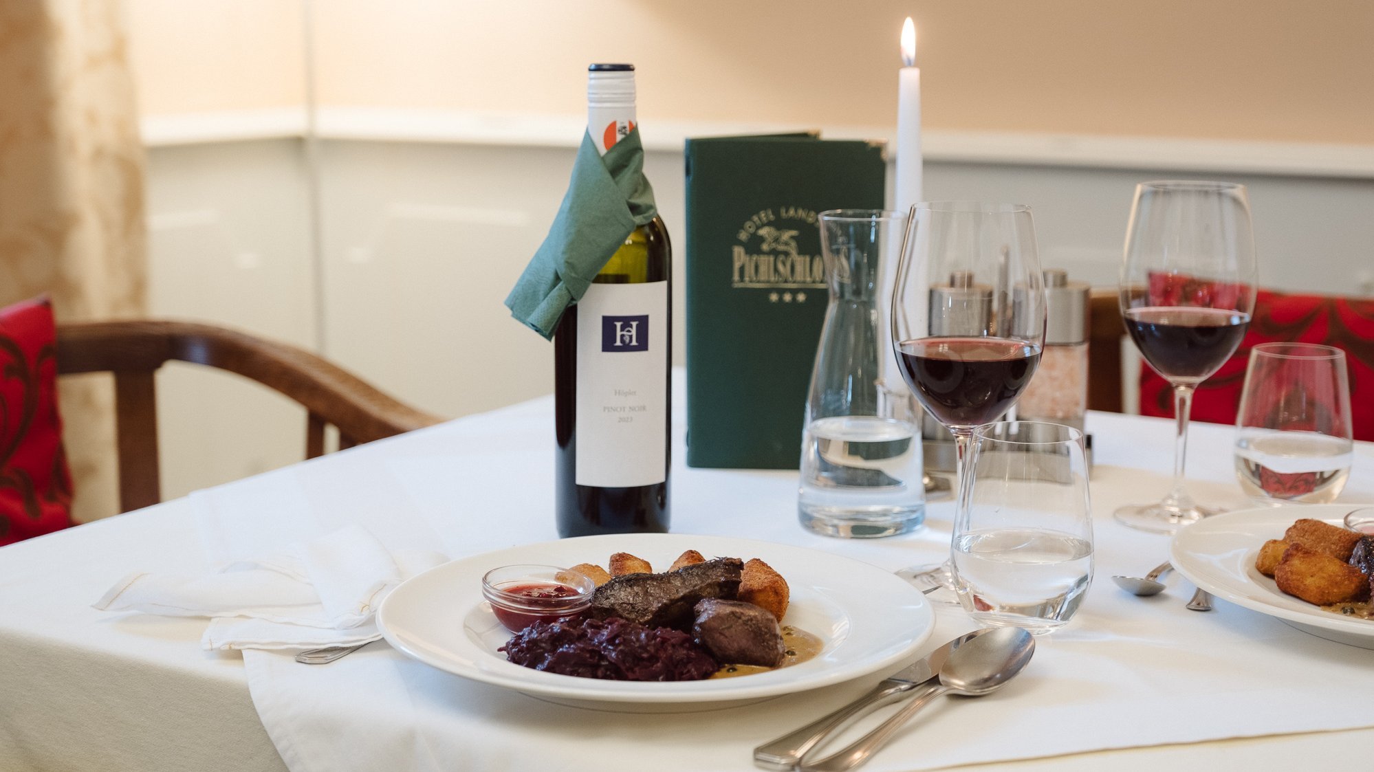 Exquisite Dining Experience A dining table elegantly set with gourmet dishes, wine, and glassware for a fine dining experience.