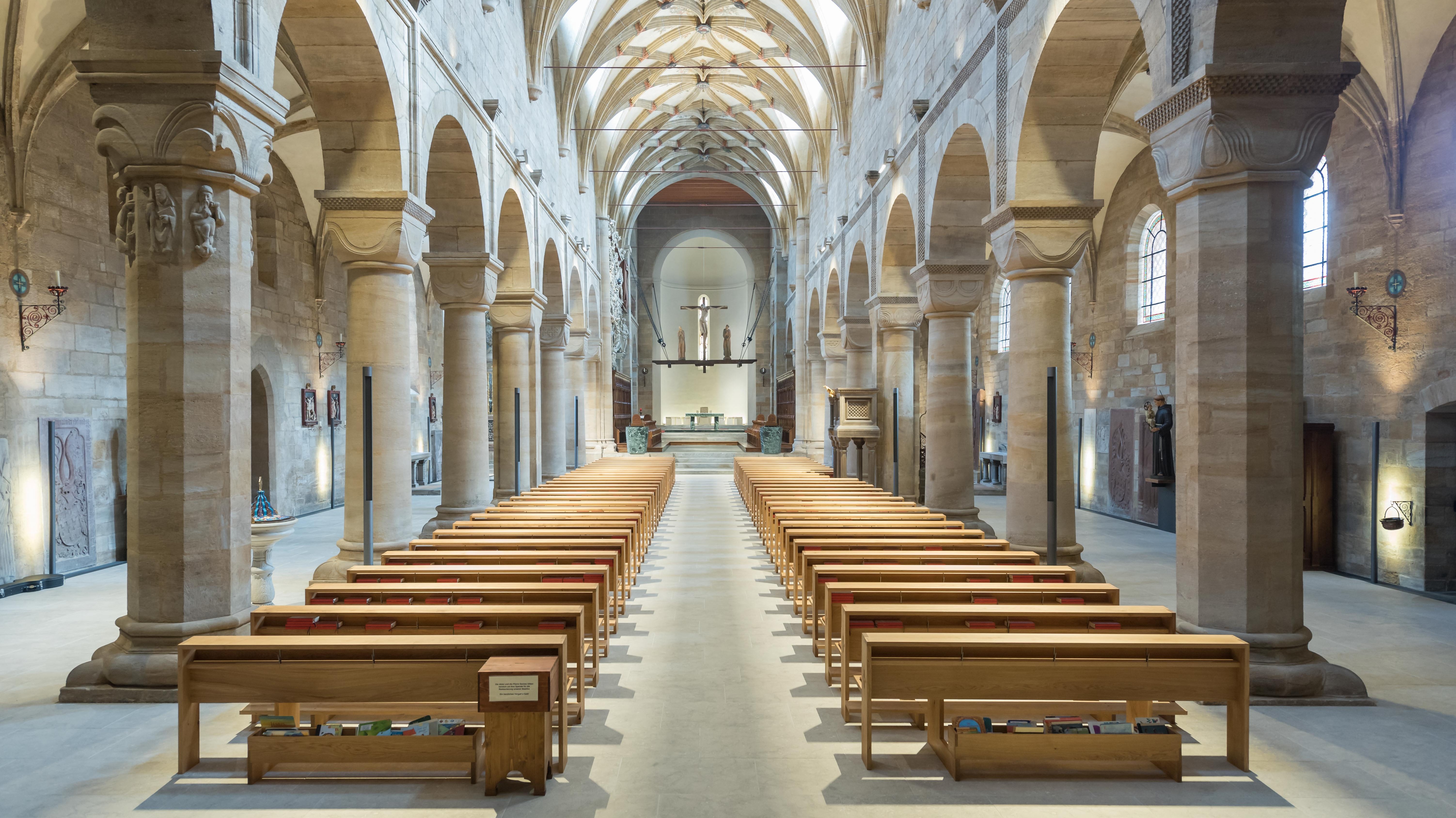 Erhabene gotische Kirchenarchitektur Innenansicht einer Kirche mit Holzbankreihen und gewölbten Decken aus Stein zum Altar hin.