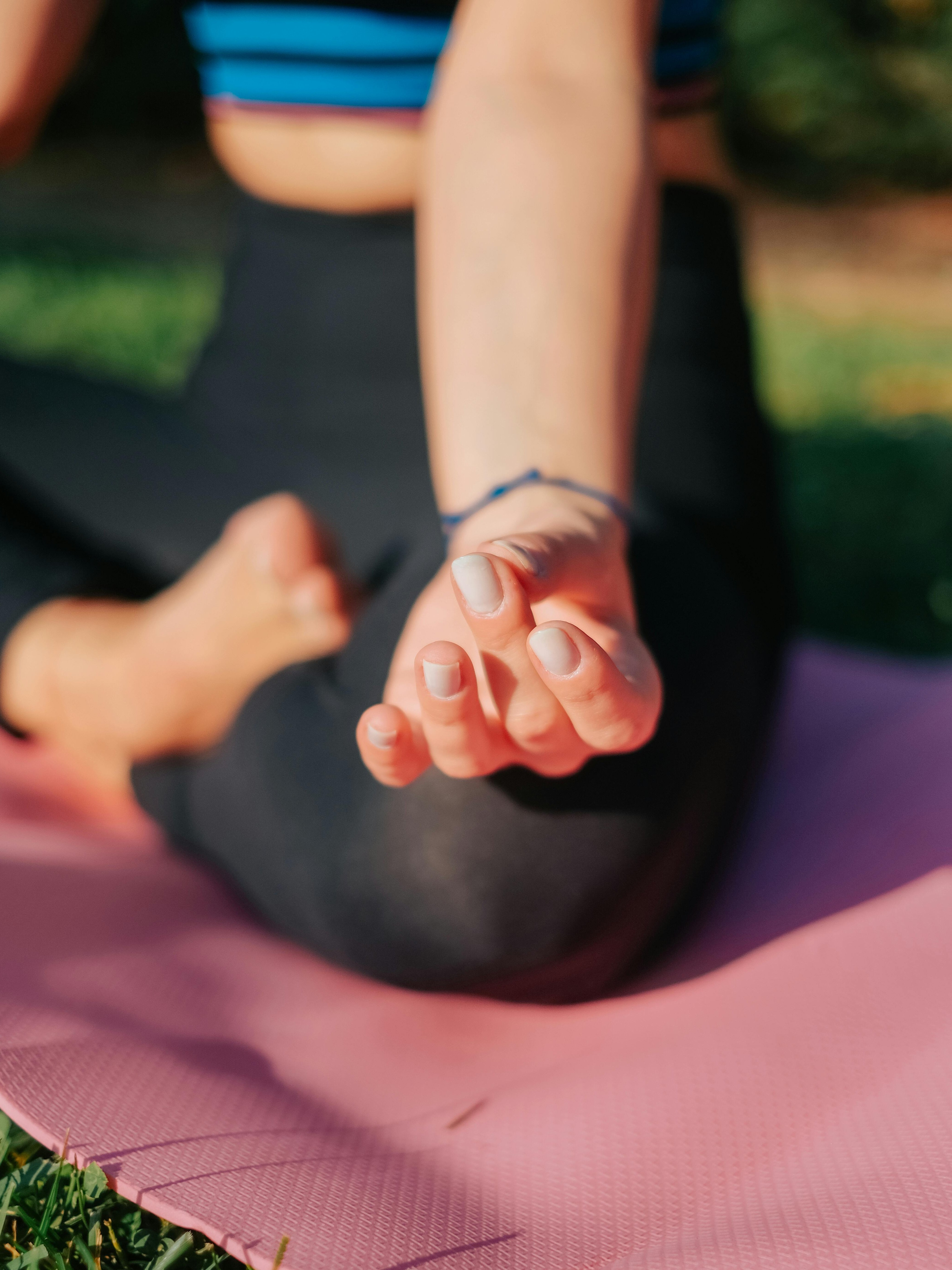 Yoga im Freien für innere Ruhe Eine Person sitzt auf einer Yogamatte und macht eine Handgeste während der Yoga-Praxis im Freien