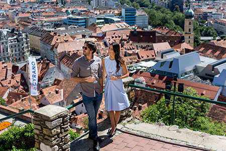 Ein Prächen genießt die Aussicht am Schlossberg über die Dächer von Graz